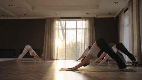 Yoga-Kurs-Von-Gesunden,-Reifen-Frauen,-Die-Kriegerpose-Praktizieren-Und-Morgens-Körperliche-Fitnessübungen-Im-Studio-Bei-Sonnenaufgang-Genießen